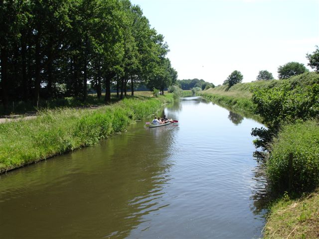 Het Valleikanaal met kanoërs tussen groene oevers